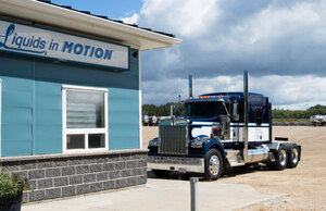 Side of Liquids in Motion Millet office with a dark blue truck parked out front 