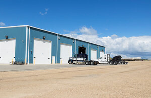 Liquids in Motion blue office and shop with three trucks parking outside