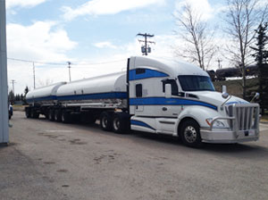 White and blue Liquids in Motion Ltd. truck delivering bulk liquids.